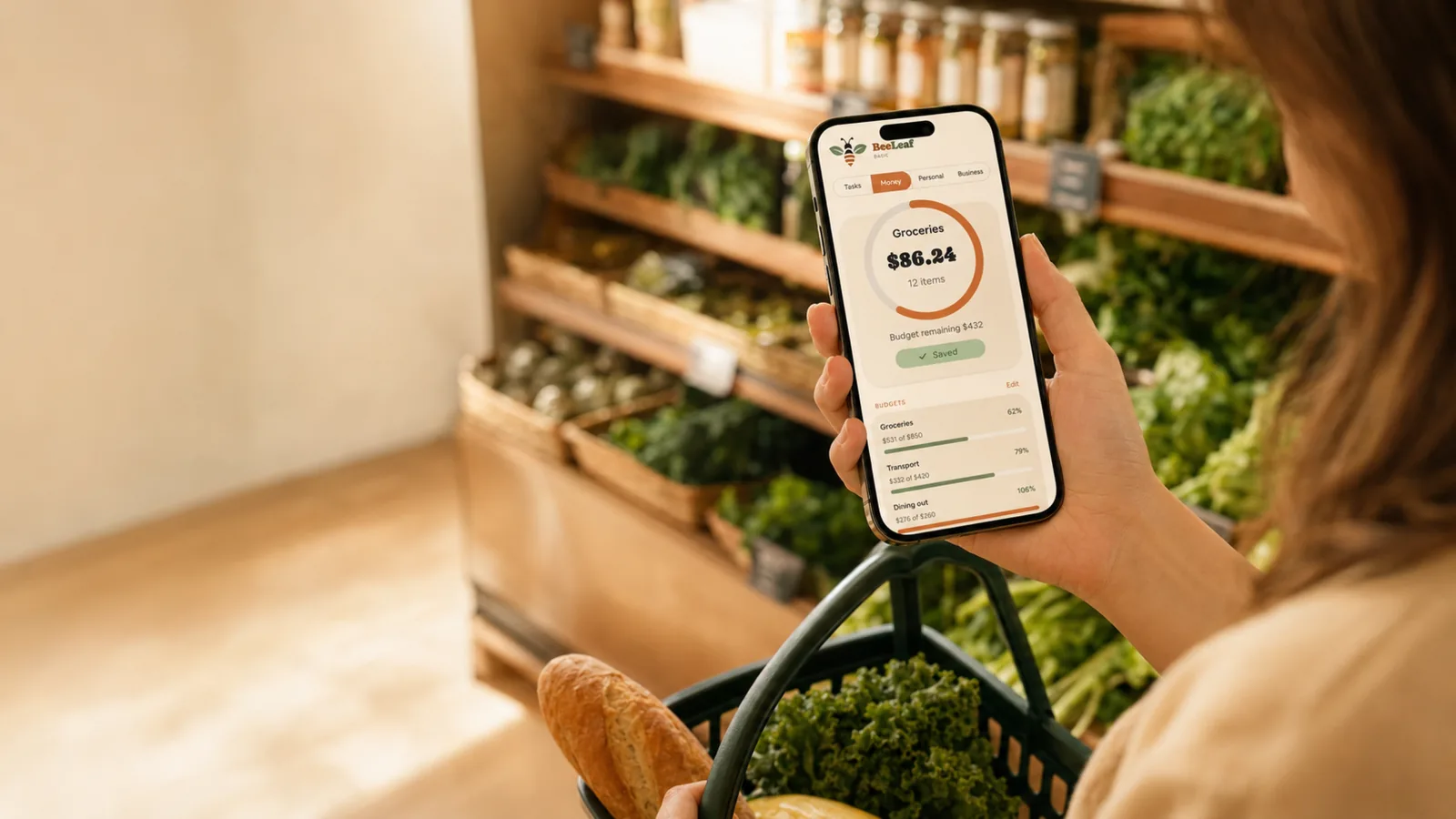 Shopper checking her BeeLeaf groceries budget of $86.24 on her phone in a grocery store